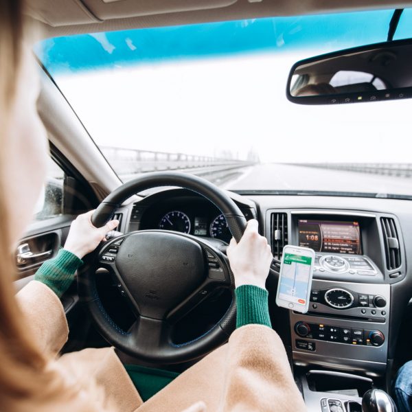 Young girl driving a car. Rear view.